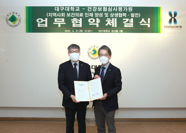 박상규(왼쪽) 대구대 총장직무대행과 황대능 건강보험심사평가원 대구지원장이 협약 체결 후 협약서를 펼쳐보이고 있다. 사진=대구대 제공