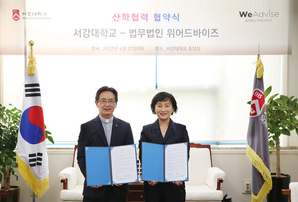 심종혁(왼쪽) 서강대 총장과 정면아 위어드바이저 대표가 산학협력 협약을 체결한 후 협약서를 펼쳐보이고 있다. 사진=서강대 제공