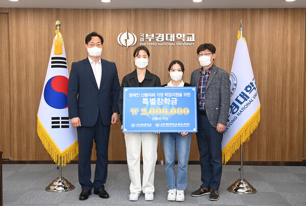 부경대 김영목 학생처장(오른쪽)과 이정규 총동창회 사무국장(왼쪽)이 학생들에게 장학금을 전달하고 기념촬영을 하고 있다. 사진=부경대 제공