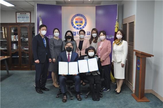 성결대 유아교육과와 모아맘 보육재단이 마련한 업무협약식에서 참석자들이 협약서를 펼쳐보이고 있다. 사진=성결대 제공