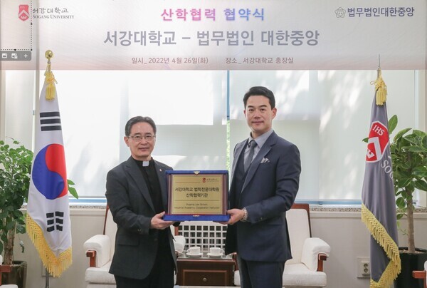 심종혁(왼쪽) 서강대 총장과 조기현 법무법인 대한중앙 대표가 산학협력 협약을 체곃한 뒤 협약서를 들어보이고 있다. 사진=서강대 제공