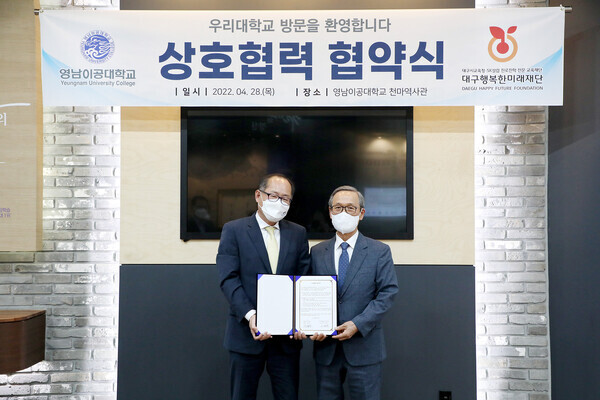 이재용(왼쪽) 총장과 이병찬 대구행복한미래재단 이사장이 업무협약을 체결한 뒤 협약서를 펼쳐보이고 있다. 사진=영남이공대 제공