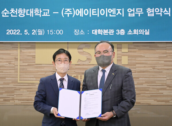 순천향대 창의라이프대학 유성용 학장(오른쪽)과 에이티이엔지 강현규 대표가 업무협약식에서 협약서를 펼쳐보이고 있다. 사진=순천향대 제공 