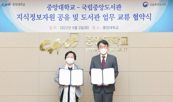 서혜란(왼쪽) 국립중앙도서관장과 박상규 중앙대 총장이 업무교류 협약식에서 협약서를 펼쳐보이고 있다. 사진=중앙대 제공