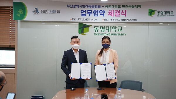 노정숙(오른쪽) 동명대 반려동물대학장과 이재호 부산시반려동물협회장이 업무협약식에서 협약서를 펼쳐보이고 있다. 사진=동명대 제공
