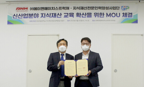 신재호(왼쪽) 경상국립대 IP사업단장과 안현수 에이엔에이치스트럭쳐 대표가 업무협약을 체결한 뒤 협약서를 펼쳐보이고 있다. 사진=경상국립대 제공