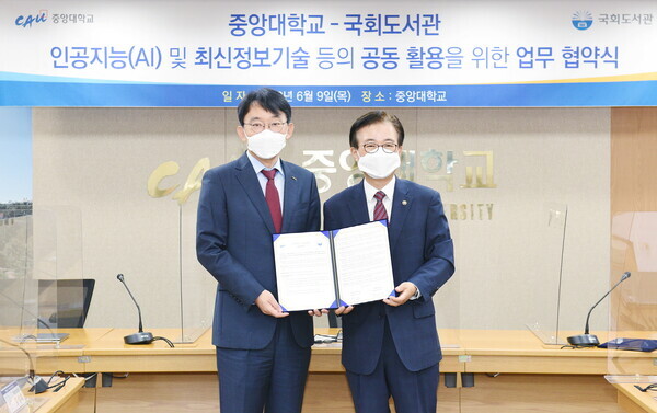 박상규(왼쪽) 중앙대 총장과 이명우 국회도서관장이 업무협약식에서 협약서를 펼쳐보이고 있다. 사진=중앙대 제공