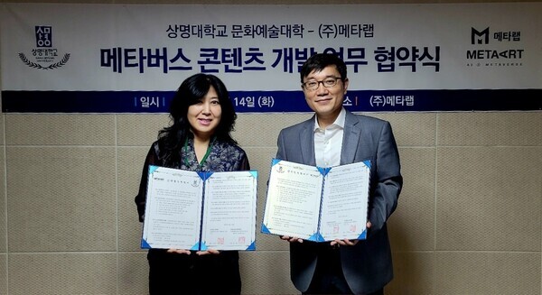 이정아(왼쪽) 상명대 문화예술대학장과 임헌 메타랩 대표가 업무협약을 맺은 뒤 협약서를 펼쳐보이고 있다. 사진=상명대 제공