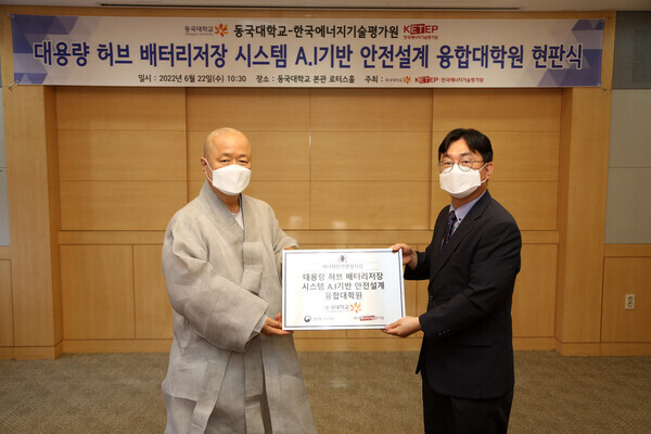 동국대 기획부총장 종호스님(왼쪽)과 한국에너지기술평가원 박재형 실장이 대용량 허브 배터리저장 시스템 AI기반 안전설계 융합대학원 현판을 들어보이고 있다. 사진=동국대 제공