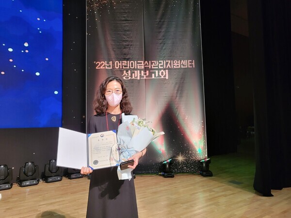 김미정 남양주시 어린이급식관리지원센터장이 어린이급식안전관리 유공 식품의약품안전처 표창을 받은 뒤 상장을 펼쳐보이고 있다. 사진=서울여대 제공