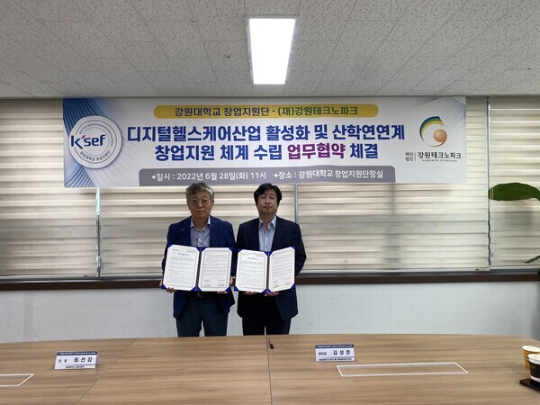 최선강(왼쪽) 강원대 창업지원단장과 김성호 강원테크노파크 헬스케어융합혁신센터장이 업무협약을 체결하고 협약서를 펼쳐보이고 있다. 사진=강원대 제공