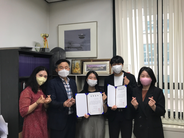 한국외국어대 김신화(가운데)씨와 김강산(오른쪽에서 두 번째)씨가 지난 28일 2022학년도 티띠낫 장학금을 받은 뒤 장학증서를 펼쳐보이며 기념촬영하고 있다. 사진=한국외대 제공