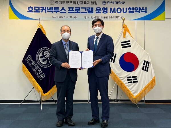 김정일(왼쪽) 한세대 총장 직무대리와 이은광 경기도군포의왕교육지원청 교육장이 '호모커넥투스 프로그램 운영을 위한 업무협약'을 체결하고 협약서를 펼쳐보이고 있다. 사진=한세대 제공