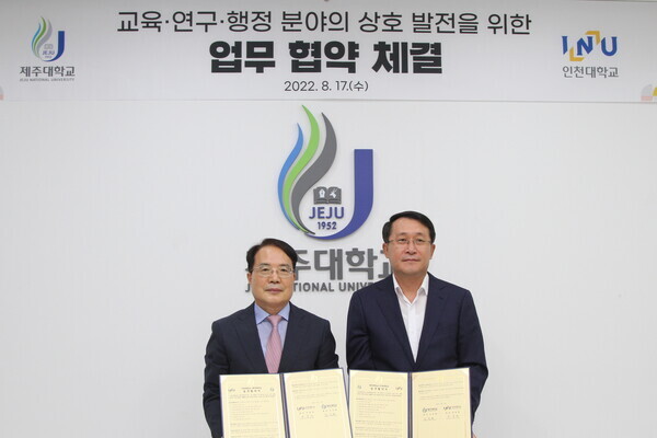 박종태(왼쪽) 인천대 총장과 김일환 제주대 총장이 업무협약을 체결한 뒤 협약서를 펼쳐보이고 있다. 사진=인천대 제공