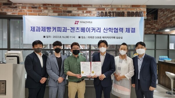 대구보건대 호텔제과제빵커피학과와 겐츠베이커리의 산학협력 협약식에서 참석자들이 협약서를 펼쳐보이고 있다. 사진=대구보건대 제공